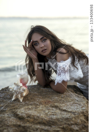 portrait of happy, carefree young woman on sandy beach against sea background. 133400698