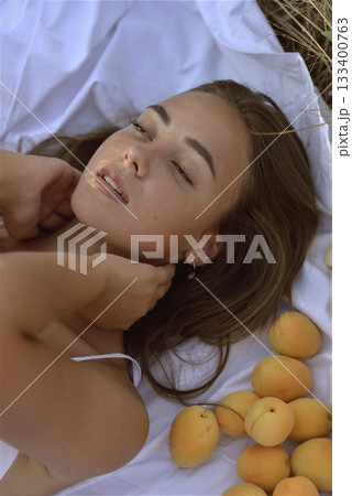 young girl in beachwear lies in the grass on the field in the rays of the setting sun young girl in beachwear lies in the grass on the field in the rays of the setting sun 133400763