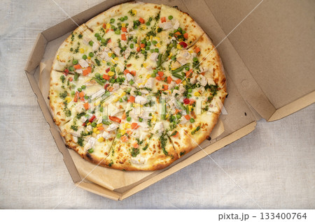 Delicious pizza with mozzarella, chicken, pepper, corn and green peas and carrots 133400764
