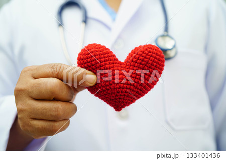 Asian woman doctor holding red heart for health in hospital. Asian woman doctor holding red heart for health in hospital. 133401436