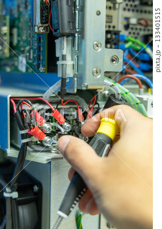 Man's hand repairing an electronic board 133401515