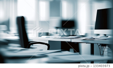 Abstract blurred office interior room. The sleek and modern office furniture, with a desk cluttered with papers and a state-of-the-art computer 133403973