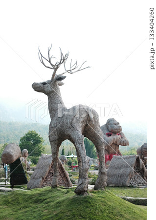 The deer puppet is made from woven straw into the shape of a large deer on green grass at Huay Tung Tao Reservoir 133404260