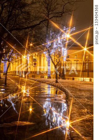 public park at night, with street lights on a tree. light is yellow, but the tree is bare. public park at night, with street lights on a tree. light is yellow, but the tree is bare. 133404368