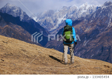 Backpacking woman hiking on high altitude mountain top 133405454
