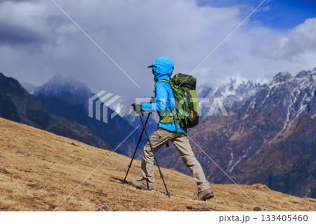 Backpacking woman hiking on high altitude mountain top Backpacking woman hiking on high altitude mountain top 133405460