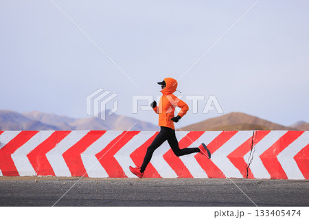 Fitness woman trail runner running on trail leading to Mount Everest in tibet, China 133405474