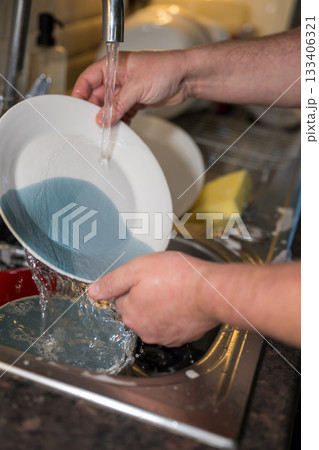 A man washing dishes in the kitchen, home chores, daily routine 133406321