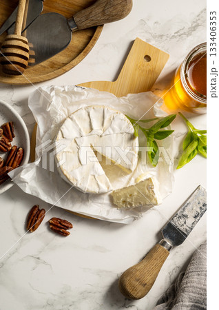 Camembert soft round cheese, served with honey, nuts and dried fruits. Cheese board 133406353
