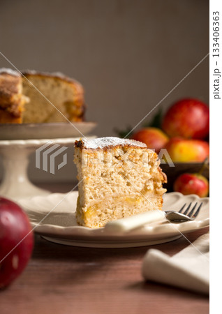 Slice of homemade apple cake with cinnamon, wooden background, lifestyle moody food photo 133406363