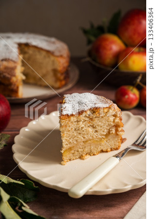 Slice of homemade apple cake with cinnamon, wooden background, lifestyle moody food photo Slice of homemade apple cake with cinnamon, wooden background, lifestyle moody food photo 133406364