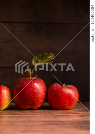 Freshly picked red apples, autumn rustic wooden background, dark, moody style 133406384