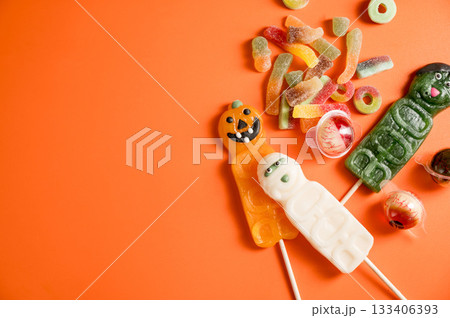 Halloween candies over orange background, eye balls, warms, pumpkins. Flat lay, copy space 133406393