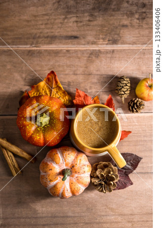 Hot drink, cosy autumn coffee drink, with apples and cinnamon, orange pumpkins, wooden rustic background 133406406