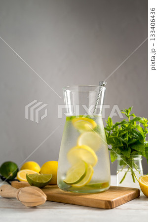 A glass jug with lemonade with lemons, limes and fresh mint, summer drink, copy space A glass jug with lemonade with lemons, limes and fresh mint, summer drink, copy space 133406436