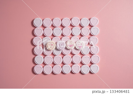 Heart-shaped candies over pink background, abstract food love background Heart-shaped candies over pink background, abstract food love background 133406481