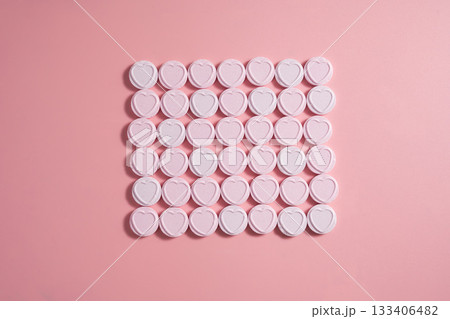 Heart-shaped candies over pink background, abstract food love background Heart-shaped candies over pink background, abstract food love background 133406482