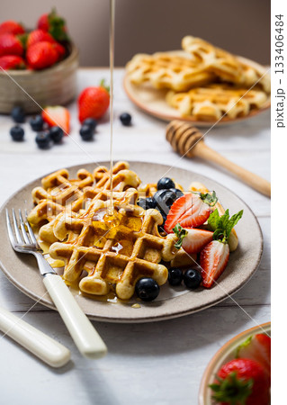 Belgian homemade waffles with strawberries, blueberries and honey 133406484