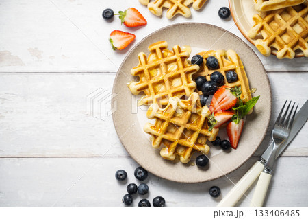 Belgian homemade waffles with strawberries, blueberries and honey, copy space Belgian homemade waffles with strawberries, blueberries and honey, copy space 133406485