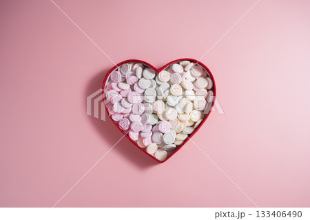 Heart-shaped candies in heart shaped box, over pink background, abstract food love background Heart-shaped candies in heart shaped box, over pink background, abstract food love background 133406490