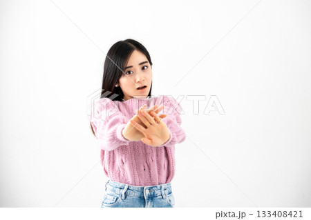 白背景の前で両手を突き出し拒否する若い女性 白背景の前で両手を突き出し拒否する若い女性 133408421