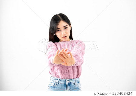 白背景の前で両手を突き出し拒否する若い女性 133408424