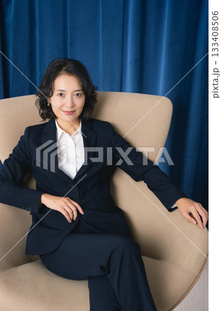大きな椅子に座るミドルビジネスウーマン 133408506