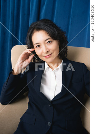 大きな椅子に座るミドルビジネスウーマン 133408510