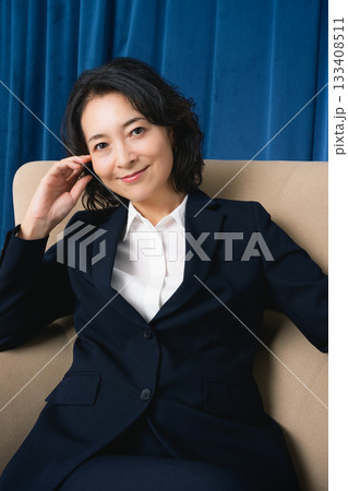 大きな椅子に座るミドルビジネスウーマン 133408511