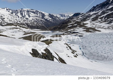 Snowy landscape viewed from high ground at Leirvassbu in Jotunheimen National Park during a clear day 133409079