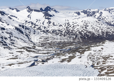 Snowy landscape in Leirvassbu showcasing the beauty of Leirdalen in Jotunheimen National Park during winter. View from Kyrkja mountain. Snowy landscape in Leirvassbu showcasing the beauty of Leirdalen in Jotunheimen National Park during winter. View from Kyrkja mountain. 133409126