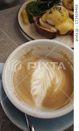 Poached eggs with hollandaise sauce served on toast with spinach and salmon slices 133409468