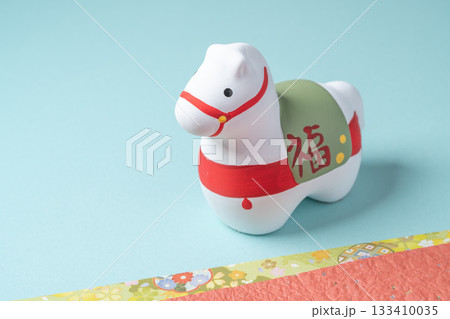 水色背景に置かれた午年の馬の置物のシンプル構図 133410035