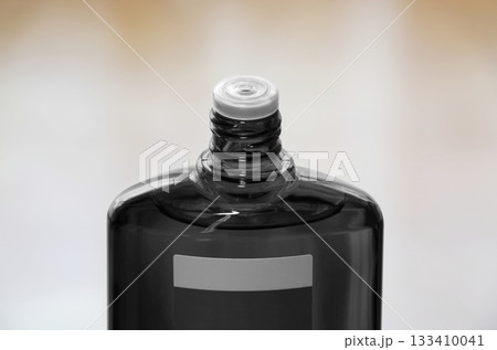 スクリューキャップを開けた育毛剤の黒色半透明のボトル スクリューキャップを開けた育毛剤の黒色半透明のボトル 133410041