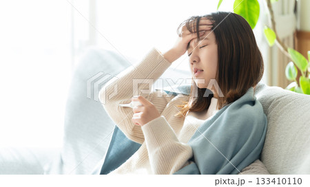 熱を測る体調不良の女性 熱を測る体調不良の女性 133410110