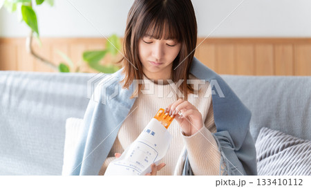 薬を飲む体調不良の女性 133410112