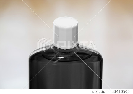 スクリューキャップを閉めた育毛剤の黒色半透明のボトル 133410500