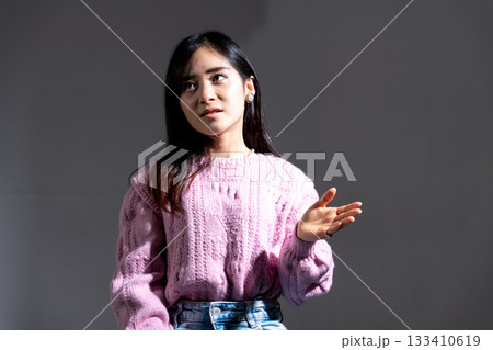 スポットライトを浴びながら話をしている若い女性 スポットライトを浴びながら話をしている若い女性 133410619
