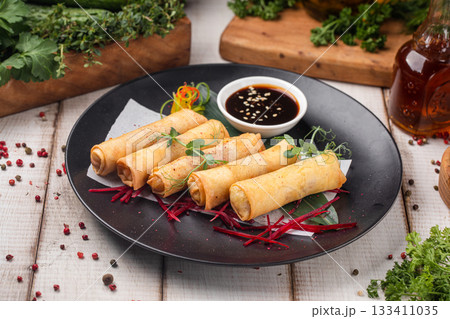 Crispy spring rolls with fresh vegetables on plate 133411035