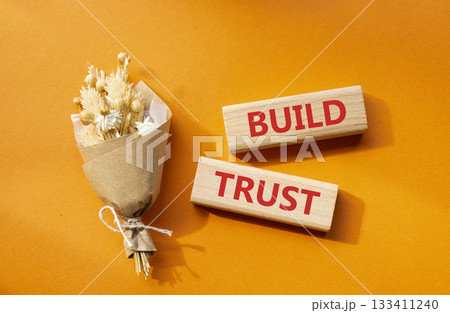 Build trust symbol. Wooden blocks with words Build trust. Beautiful orange background with bouquet of flowers. Business and Build trust concept. Copy space. Build trust symbol. Wooden blocks with words Build trust. Beautiful orange background with bouquet of flowers. Business and Build trust concept. Copy space. 133411240