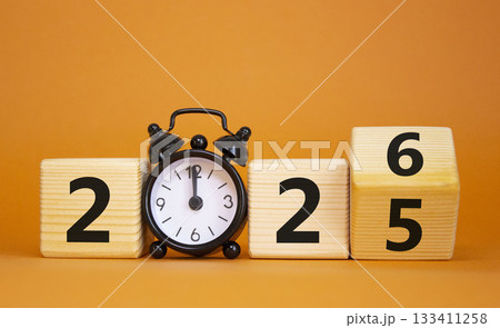 2026 New Year symbol. Businessman turns wooden cube and changes Year 2025 to 2026. Beautiful orange background with Alarm clock. Copy space. Business and 2026 happy new year concept 2026 New Year symbol. Businessman turns wooden cube and changes Year 2025 to 2026. Beautiful orange background with Alarm clock. Copy space. Business and 2026 happy new year concept 133411258