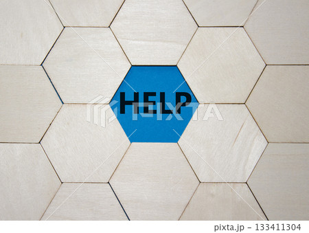 Help symbol. Concept word help on wooden comb puzzle. Beautiful blue background. Business and help concept. Copy space. Help symbol. Concept word help on wooden comb puzzle. Beautiful blue background. Business and help concept. Copy space. 133411304
