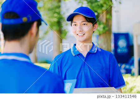 荷物を届ける宅配便の若いドライバー 133411546