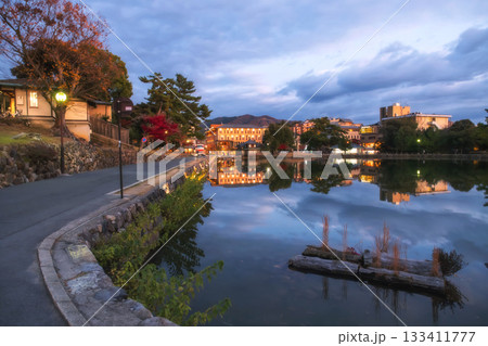 Nara town skyline reflection in Sarusawaike pond in autumn at dusk 133411777
