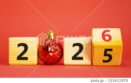 2026 New Year symbol. Businessman turns wooden cube and changes Year 2025 to 2026. Beautiful red background with christmas ball. Copy space. Business and 2026 happy new year concept 2026 New Year symbol. Businessman turns wooden cube and changes Year 2025 to 2026. Beautiful red background with christmas ball. Copy space. Business and 2026 happy new year concept 133411979