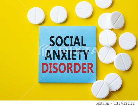 Social Anxiety Disorder symbol. Concept words Social Anxiety Disorder on blue note. Beautiful yellow background with pills. Healthcare and Social Anxiety Disorder concept. Copy space. Social Anxiety Disorder symbol. Concept words Social Anxiety Disorder on blue note. Beautiful yellow background with pills. Healthcare and Social Anxiety Disorder concept. Copy space. 133412113