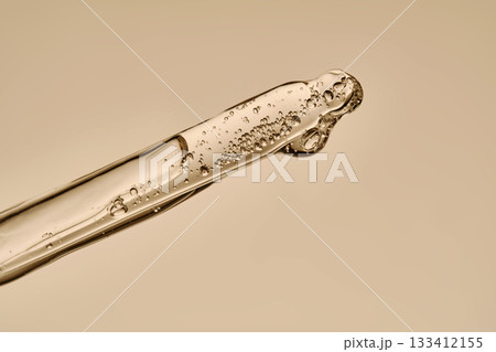 The texture of the hyaluronic serum flowing down the dropper. The texture of the hyaluronic serum flowing down the dropper. 133412155