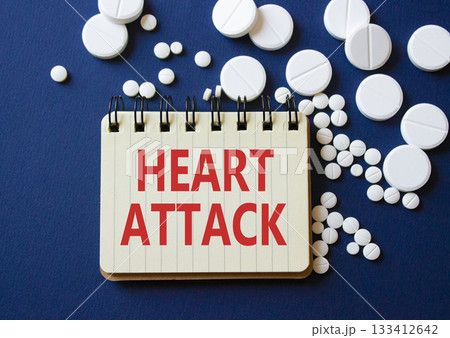 Heart Attack symbol. Concept word Heart Attack on notebook. Beautiful deep blue background with pills. Medicine and Heart Attack concept. Copy space Heart Attack symbol. Concept word Heart Attack on notebook. Beautiful deep blue background with pills. Medicine and Heart Attack concept. Copy space 133412642