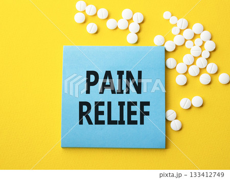 Pain Relief symbol. Concept word Pain Relief on blue note. Beautiful yellow background with pills. Medicine and Pain Relief concept. Copy space Pain Relief symbol. Concept word Pain Relief on blue note. Beautiful yellow background with pills. Medicine and Pain Relief concept. Copy space 133412749