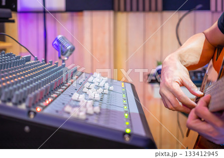 close up male musician hands playing acoustic guitar in home studio, recording concept. close up male musician hands playing acoustic guitar in home studio, recording concept. 133412945